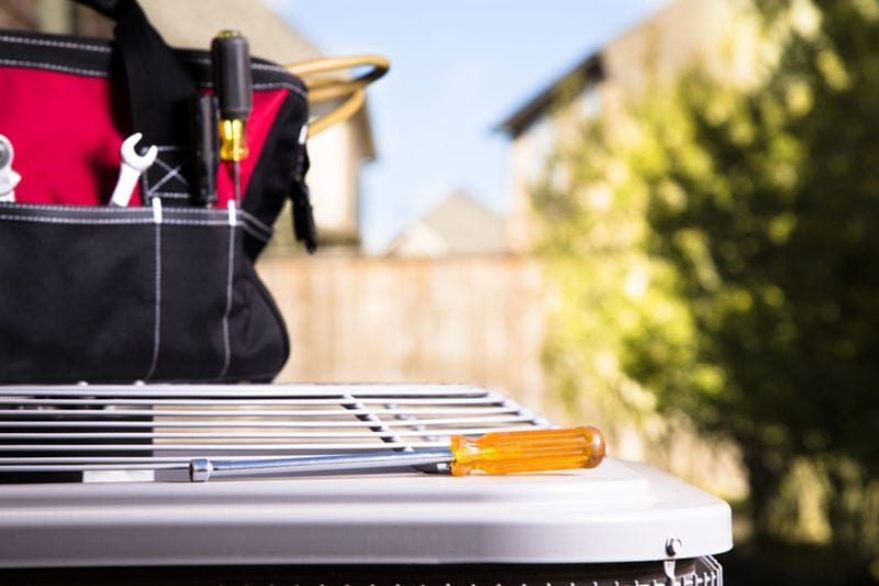 Service Industry: Work tools on air conditioner. Outside home.