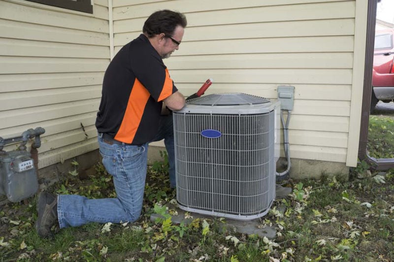 Repairman Checking Outside Air Conditioning Unit For Voltage