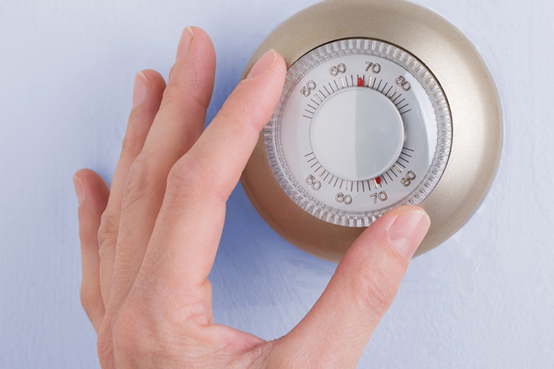 hand on thermostat