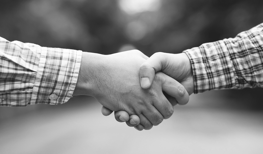 Businessmen in plaid shirts shake hands to greet each other And make an agreement