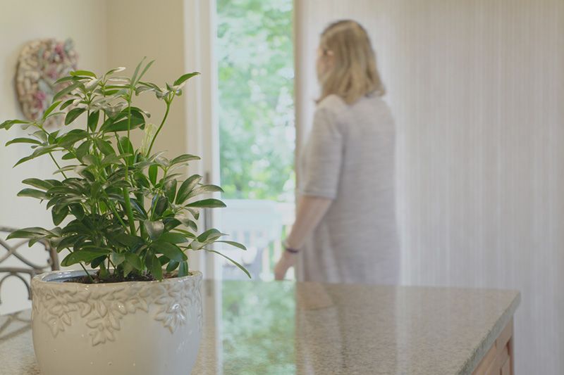 Energy Saving Tip 3. Image of homeowner closing blind.